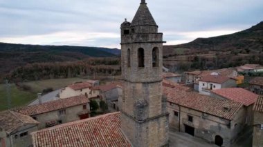 Eski ortaçağ geleneksel mimari köyü Luzas 'ın panoramik insansız hava aracı görüntüsü ve San Cristobal' ın Roma kilisesinin kilise çan kulesi. Huesca ili, Aragon, İspanya. 4K video
