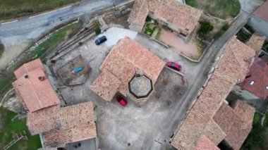 Eski ortaçağ geleneksel taş evleri, Luzas köyündeki evlerin kiremit çatıları ve San Cristobal 'daki Roma kilisesinin kilise çan kulesinin panoramik insansız hava aracı görüntüsü. Huesca, Aragon, Spain4K video