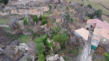Luzas köyünün tarihi merkezindeki ortaçağ geleneksel taş evleri ve San Cristobal 'ın Roma kilisesinin kilise çan kulesinin panoramik insansız hava aracı görüntüsü. Huesca, Aragon, İspanya. 4K