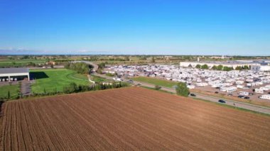 Yıllık kamp minibüslerinin (Salone del Camper) sergilendiği otopark manzaralı modern kampçılar. Özgür hissetmek için en iyi yol. Parma, İtalya - 17 Eylül 2022. 4K