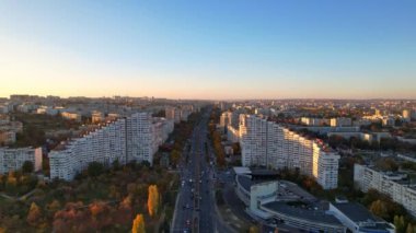 Dacia Bulvarı 'ndaki Chisinau şehrinin panoramik insansız hava aracı görüntüsü. Yol, ağaçlar, park, göl manzarası, sonbahar mevsiminde Chisinau 'nun binaları, Moldova Cumhuriyeti' nin başkenti. 4K video