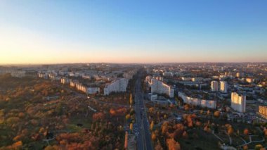 Dacia Bulvarı 'ndaki Chisinau şehrinin panoramik insansız hava aracı görüntüsü. Yol, ağaçlar, park, göl manzarası, sonbahar mevsiminde Chisinau 'nun binaları, Moldova Cumhuriyeti' nin başkenti. 4K video
