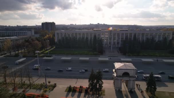 モルドバのシナウ市中心部の背景にあるモルドバ共和国の旗を持つ政府の建物を持つトライアンファルアーのパノラマ空中ドローンビュー 4Kビデオ — ストック動画