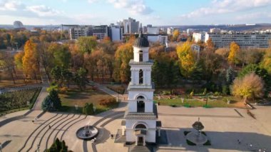 Çan kulesi olan Central Park 'ın panoramik hava aracı görüntüsü ve Chisinau' da Çan kulesi olan İsa 'nın Doğumu Katedrali, arka planda birçok ofis ve yerleşim binası bulunan Moldova. 4K video