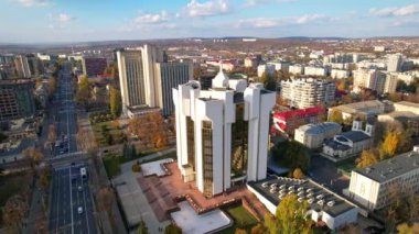 Moldova Cumhuriyeti bayrağı taşıyan cumhurbaşkanının resmi ikametgahının panoramik hava aracı görüntüsü. Chisinau 'daki Başkanlık Sarayı' nın arka planında birden fazla ofis ve konut binaları var. 4K video