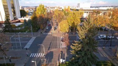 Sonbahar sezonunda Moldova Cumhuriyeti 'nin tepesinde bayrak bulunan başkanlık binasının panoramik hava aracı görüntüsü. Birden fazla ofis, konut binaları, arka planda giden arabalar. Chisinau, Moldova. 4K