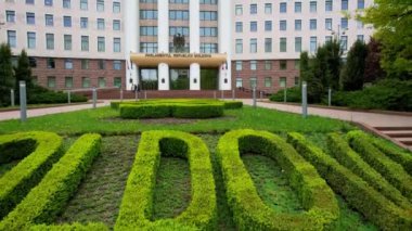 İlkbahar zamanı Chisinau 'daki Moldova Parlamentosu binasının panoramik hava aracı görüntüsü. Moldova Parlamentosu - Parlamentul Republicii Moldova binasının girişinde ana yazıt. 4K