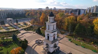 Çan kulesi olan Central Park 'ın panoramik hava aracı görüntüsü ve Chisinau' da Çan kulesi olan İsa 'nın Doğumu Katedrali, arka planda birçok ofis ve yerleşim binası bulunan Moldova. 4K video