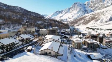 Kayak pistlerindeki panoramik hava aracı manzarası, dağ kayağı ve popüler tatil köyü. Aosta Vadisi 'ndeki Alplerdeki İtalyan kayak merkezi. Kış manzarası. İtalya, Breuil Cervinia. 4K video
