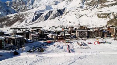 Kayak pistlerindeki panoramik hava aracı manzarası, dağ kayağı ve popüler tatil köyü. Aosta Vadisi 'ndeki Alplerdeki İtalyan kayak merkezi. Kış manzarası. İtalya, Breuil Cervinia. 4K video