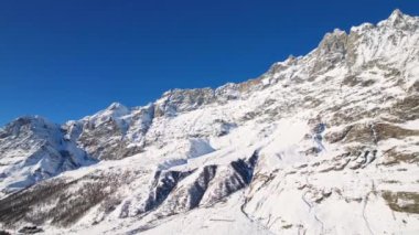 Kayak pistlerindeki panoramik hava aracı manzarası, dağ kayağı ve İsviçre ve İtalya sınırındaki popüler tatil köyü. Aosta Vadisi, Breuil Cervinia 'daki Alpler' de kış manzarası. 4K video