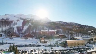 Kayak pistlerindeki panoramik hava aracı manzarası, dağ kayağı ve popüler tatil köyü. Aosta Vadisi 'ndeki Alplerdeki İtalyan kayak merkezi. Kış manzarası. İtalya, Breuil Cervinia. 4K video