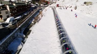 Kayak pistlerindeki panoramik hava aracı manzarası, dağ kayağı ve popüler tatil köyü. Aosta Vadisi 'ndeki Alplerdeki İtalyan kayak merkezi. Kış manzarası. İtalya, Breuil Cervinia. 4K video