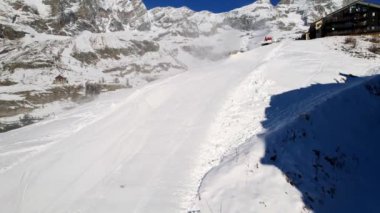 Kayak pistlerindeki panoramik hava aracı manzarası, dağ kayağı ve İsviçre ve İtalya sınırındaki popüler tatil köyü. Aosta Vadisi, Breuil Cervinia 'daki Alpler' de kış manzarası. 4K video