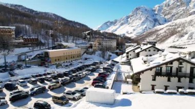 Kayak pistlerindeki panoramik hava aracı manzarası, dağ kayağı ve popüler tatil köyü. Aosta Vadisi 'ndeki Alplerdeki İtalyan kayak merkezi. Kış manzarası. İtalya, Breuil Cervinia. 4K video