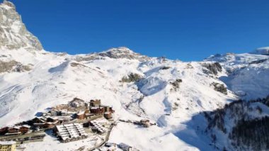 Kayak pistlerindeki panoramik hava aracı manzarası, dağ kayağı ve popüler tatil köyü. Aosta Vadisi 'ndeki Alplerdeki İtalyan kayak merkezi. Kış manzarası. İtalya, Breuil Cervinia. 4K video
