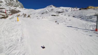 Kayak pistlerindeki panoramik hava aracı manzarası, dağ kayağı ve popüler tatil köyü. Aosta Vadisi 'ndeki Alplerdeki İtalyan kayak merkezi. Kış manzarası. İtalya, Breuil Cervinia. 4K video