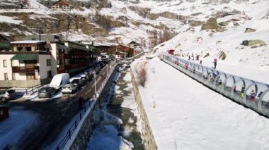 Kayak pistlerindeki panoramik hava aracı manzarası, dağ kayağı ve İsviçre ve İtalya sınırındaki popüler tatil köyü. Aosta Vadisi, Breuil Cervinia 'daki Alpler' de kış manzarası. 4K video