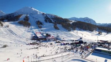 Piedmont 'ta kış mevsiminde olan Sestriere' deki Alp köyünün kar kaplı yamaçlarında güzel panoramik hava aracı manzarası. 4K video