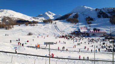 Piedmont 'ta kış mevsiminde olan Sestriere' deki Alp köyünün kar kaplı yamaçlarında güzel panoramik hava aracı manzarası. 4K video