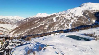 İtalya 'nın batısındaki Alpler' deki ünlü kayak merkezi Sestriere köyünün dağları üzerinde güzel panoramik hava aracı görüntüsü. 4K video