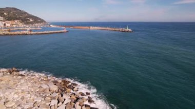 Imperia, İtalya 'yı keşfedin, deniz fenerinin çarpıcı hava manzaraları, parıldayan deniz, canlı liman. Bu görüntüler sahil cazibesini ve hareketli liman yaşamını kapsıyor, seyahat için, ticari kullanım için.