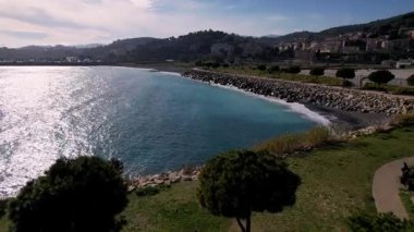 Kendinizi Imperia, İtalya 'nın sakin cazibesine bırakın. İHA görüntüleriyle. Yeşil parkların ve ışıltılı denizin üzerinde uç, doğanın ve kentsel cazibenin ahenkli bir karışımını sunarak