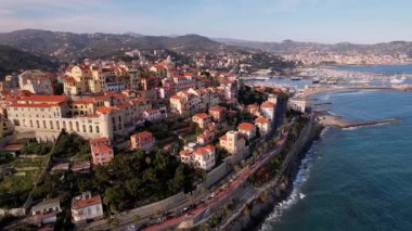 İtalya 'nın tarihi Imperia şehrinin üzerinde süzülür, sakin sahil şeridi, aşıkların ikonik yürüyüşü sergilenir. Bu büyüleyici drone görüntüsü İtalyan romantizmini vurguluyor, büyüleyici stok videoları için ideal.