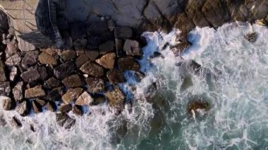 Doğanın gücünü kayalık kıyılara çarpan dalgaların bu dramatik drone görüntüsüyle hissedin. Pazarlama, belgeseller, görsel sanat projeleri için bu video okyanus güzelliğinin özünü yakalıyor.