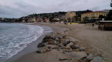 Taggia, İtalya 'nın nefes kesici insansız hava aracı görüntüleriyle nefes kesici güzelliğini tecrübe edin. Resimli kıyı manzaraları, canlı şehir mimarisi, dingin dalgalar, seyahat ve yaşam tarzı projeleri için mükemmel