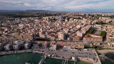 Syracuse, İtalya 'da insansız hava aracı keşiflerine çıkın, şehirlerin ikonik mirasını ve cennet kıyı şeritlerini sergileyin. Parlak yatlar, güneşli denizde sürükleniyor. Lüks ve sükunetin büyüleyici bir sahnesini oluşturuyor.