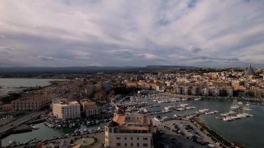 Syracuse, İtalya 'da insansız hava aracı keşiflerine çıkın, şehirlerin ikonik mirasını ve cennet kıyı şeritlerini sergileyin. Parlak yatlar, güneşli denizde sürükleniyor. Lüks ve sükunetin büyüleyici bir sahnesini oluşturuyor.