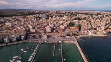 Syracuse, İtalya 'nın büyüleyici sahil cazibesini yukarıdan gözler önüne seriyor. Yatlar kristal-lear Akdeniz sularında zarifçe gezinirken, tarihi simgeler ve sakin kıyıların ahenkli birleşimine hayret ediyorum.