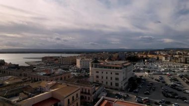 Tarihin gök mavisi dalgalarıyla buluştuğu İtalya 'nın Syracuse kentinin nefes kesici hava manzarası. Şahit büyüleyici şehir manzarası resimli kıyı şeridiyle uyumlu bir şekilde harmanlanıyor. Zarif yatlar pırıl pırıl denizler