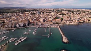 İtalya 'nın Syracuse şehrinde insansız hava aracıyla, mimari harikalarının, altın sahillerinin görkemli görüntüsünü yakalayacağız. Deniz yatlarla parıldıyor, zarif bir dans eşliğinde sularda zikzak çiziyor.