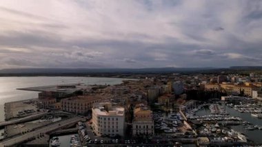 İtalya 'nın Syracuse kentindeki çarpıcı drone panoramasını keşfedin. Antik mimari ve manzaralı kıyı şeritleri hayal gücünü cezbediyor. Görkemli yatlar berrak mavi suları süsler, şehirleri güzelleştirir.