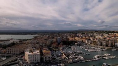 İtalya 'nın Syracuse şehrinde insansız hava aracıyla, mimari harikalarının, altın sahillerinin görkemli görüntüsünü yakalayacağız. Deniz yatlarla parıldıyor, zarif bir dans eşliğinde sularda zikzak çiziyor.