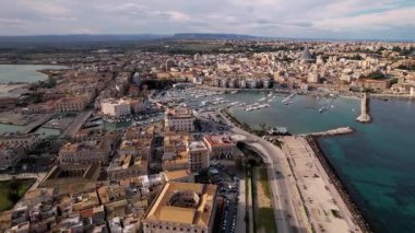 Syracuse, İtalya 'da insansız hava aracı keşiflerine çıkın, şehirlerin ikonik mirasını ve cennet kıyı şeritlerini sergileyin. Parlak yatlar, güneşli denizde sürükleniyor. Lüks ve sükunetin büyüleyici bir sahnesini oluşturuyor.