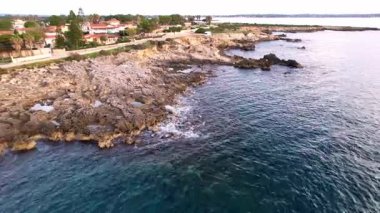 Sicilya 'lı Ognina Spiaggia di Punta Asparano' nun nefes kesici insansız hava aracı görüntüleri. Göz kamaştırıcı sahil uçurumlarının üzerinde süzülür, doğal kayalık kemer, parıldayan Akdeniz kıyıları. Seyahat ve doğa tutkunları için