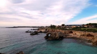 Ognina Spiaggia di Punta Asparano, Sicilya 'nın güzelliğini insansız hava aracı görüntüleriyle gözler önüne sermek. Görkemli kayalıkları, doğal bir kemeri ve uçsuz bucaksız mavi denizi yakalamak. Nefes kesici görüntüler için mükemmel.