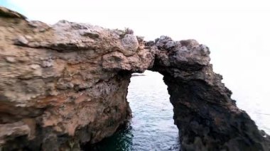 Sicilya 'lı Ognina Spiaggia di Punta Asparano' nun insansız hava aracı görüntüleriyle duyularınızı yükseltin. Engebeli uçurumlar, görkemli bir kemer ve sakin kıyı manzaraları. Cennetin mükemmel bir parçası