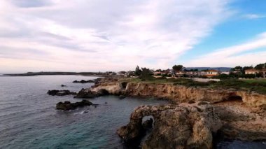 Sicilya 'lı Ognina Spiaggia di Punta Asparano' nun insansız hava aracı görüntüleriyle duyularınızı yükseltin. Engebeli uçurumlar, görkemli bir kemer ve sakin kıyı manzaraları. Cennetin mükemmel bir parçası