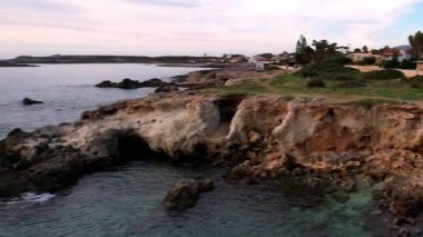 Sicilya 'lı Ognina Spiaggia di Punta Asparano' nun insansız hava aracı görüntüleriyle duyularınızı yükseltin. Engebeli uçurumlar, görkemli bir kemer ve sakin kıyı manzaraları. Cennetin mükemmel bir parçası
