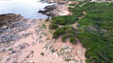 Ognina Spiaggia di Punta Asparano Sicilya kıyı şeridinin dramatik insansız hava aracı çekimleriyle bizi çağırıyor. Kayalık manzaralar, davetkar kemer ve el değmemiş sular. Huzurlu kaçışlar için mükemmel bir manzara