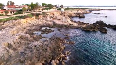 Sicilya 'lı Ognina Spiaggia di Punta Asparano' nun insansız hava aracı görüntüleriyle duyularınızı yükseltin. Engebeli uçurumlar, görkemli bir kemer ve sakin kıyı manzaraları. Cennetin mükemmel bir parçası