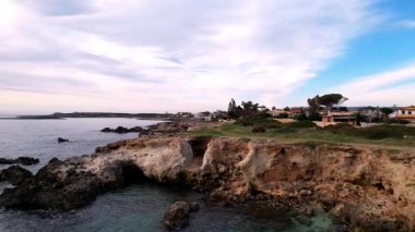 Ognina Spiaggia di Punta Asparano, Sicilya 'nın güzelliğini insansız hava aracı görüntüleriyle gözler önüne sermek. Görkemli kayalıkları, doğal bir kemeri ve uçsuz bucaksız mavi denizi yakalamak. Nefes kesici görüntüler için mükemmel.