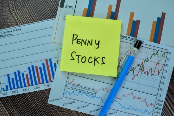 Concept of Penny Stocks write on sticky notes isolated on Wooden Table.