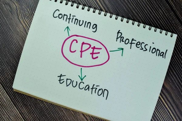 Concept of CPE - Continuing Professional Education write on sticky notes isolated on Wooden Table.