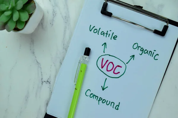 Concept of VOC - Volatile Organic Compound write on paperwork isolated on Wooden Table.