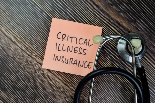 Concept of Critical Illness Insurance write on sticky notes isolated on Wooden Table.